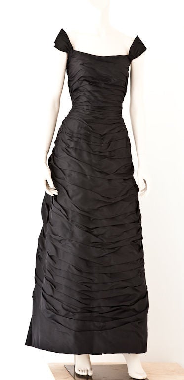 This black silk taffeta structured dress of a belle epoque inspired silhouette is reminiscent of the  Christian Dior Couture gowns of the 50's. It may be a copy, since there are no labels to be found.The bodice is very fitted and is horizontally