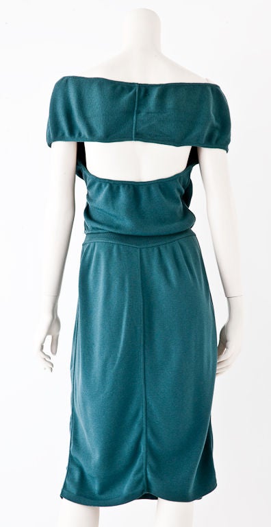 Azzedine Alaia 2 piece wool knit ensemble in a beautiful shade of teal blue. Top has criss cross deep neckline with a cap sleeve and open back. Skirt is straight with knitted band waist.