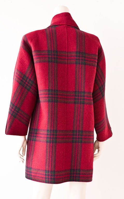 Oscar de la Renta double breasted, pomegranate red, bold plaid double face wool coat with large front pocket detail. Shawl, pointed collar and dolman sleeves. 3/4 length, can be worn with dresses and pants.  Plaid has shades of forest green and dark
