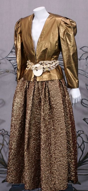 Bill Blass evening ensemble of copper kid leather and copper lame cloque. Fitted jacket with pleated shoulders is versatile enough to wear for day. Full gathered skirt.<br />
Belt not included.<br />
Size "8" US<br />
Jacket length: