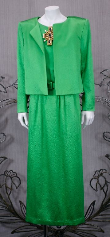 YSL Haute Couture hammered satin evening suit in jade green. Easy T shirt shaped top and slim gathered floor length with rear kick pleat. Extreme shoulder bolero jacket. Self belt.
Extremely chic timeless design.<br />
Fabric: 55% wool, 45% silk.