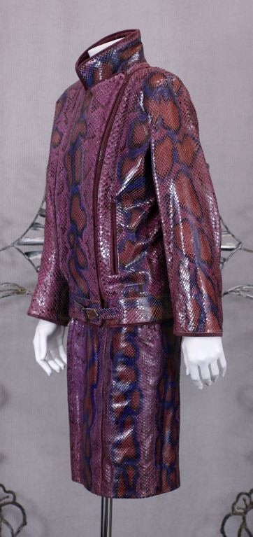 Extraordinary Snake Motorcycle Jkt and skirt in shades of plum, purple and cinnabar. Plum suede collar and piped edges. Heavy side zip with slashed front pockets. Slim skirt with suede piped seams.
This garment exhibits YSL's gift of elevating