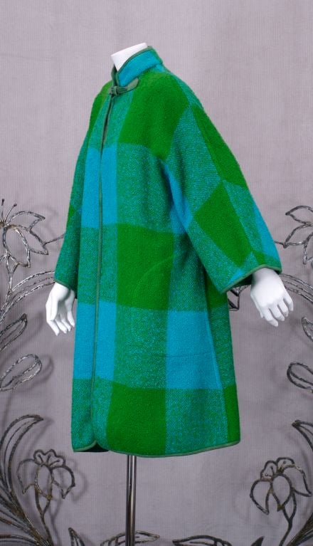 Bonnie Cashin for Sills car coat in green/turq. plaid boucle with suede piping.<br />
Clean lined Kimono style sleeves with single suede buckle closure at neck and side seam pockets.<br />
Length: 38"<br />
Seam over arm: 24"