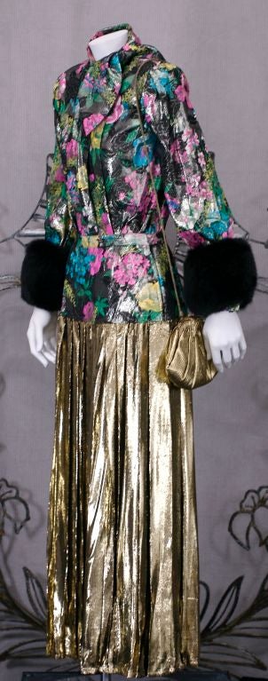 Adolfo 2 piece floral and gold lame ensemble. Floral lame blouse with self scarf and mink trimmed cuffs. A yoke of the same floral lame encircles the hips and releases into a full pleated gold lame skirt. The 2 piece is designed to give the