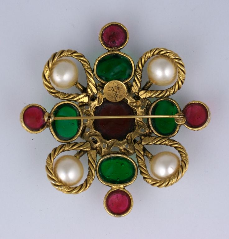 Iconic Chanel Crest brooch made by the Gripoix studios circa 1980s. Poured glass in emerald and ruby with faux pearls and pastes in excellent condition. Gilt metal.<br />
Signed 