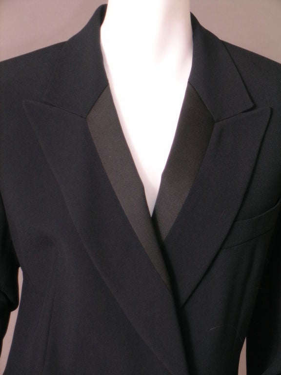 From the French design house founded by Nino Cerruti, this black wool and satin tuxedo dress is both elegant and sexy.<br />
<br />
The double breasted dress has notched lapels with satin inserts.  In true tuxedo fashion there are three pockets,
