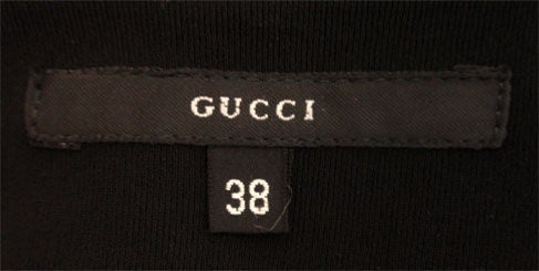 This is a long black fitted stretch dress by Gucci, and the personal property of Melanie Griffith. It has long sleeves, a slit down the left side seam, and a scoop neckline.<br />
<br />
This black stretch dress by Gucci is available to be viewed