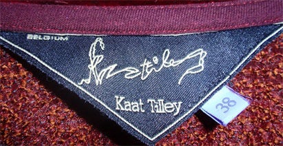 This is a long burgundy evening coat by Kaat Tilley from Belgium, and the personal property of Melanie Griffith. The evening coat has five buttons in the center front, silk lace ties in the back, velvet detail on the collar, cuff, and hem.<br