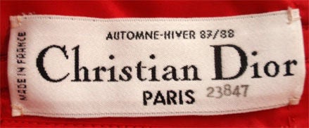 This is an amazing red strapless Haute Couture gown by Christian Dior, from Autome-Hiver 1987-1988. The gown is silk taffeta with black velvet trim , boning in the structured bodice, and a large bow on the back.<br />
<br />
This red strapless