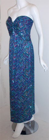 This is a long, multi colored, silk beaded gown by Bob Mackie, from 1980. The gown is strapless with beading all over, a constructed bustier, and a zipper up the back. <br />
<br />
This beaded gown by Bob Mackie is available to be viewed privately