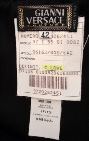 Il s'agit d'une robe stretch noire et chatoyante de Gianni Versace Couture, propriété personnelle de Courtney Love, datant de 1996. La robe est drapée sur les épaules pour former un col bénitier très ouvert, des manches longues de 25 pouces et une