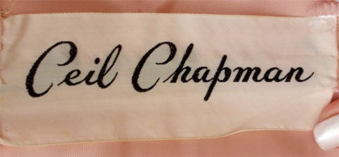 Dies ist eine sammelbare rosa Spitze Vintage Cocktail-Kleid von Ceil Chapman, aus den 1950er Jahren. Das Kleid hat einen Rundhalsausschnitt, einen langen Rock, lange Ärmel und einen Reißverschluss auf der Rückseite. 

Aufgrund einiger