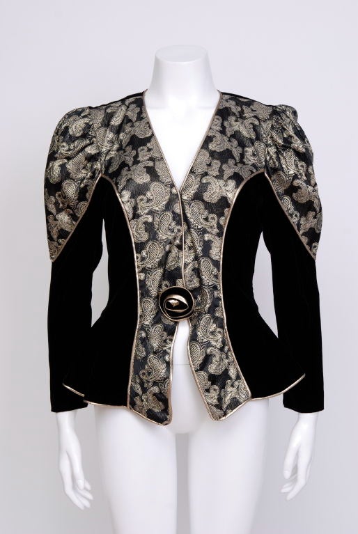 80's black velvet, metallic brocade, single breasted peplum blazer with rose closure at front and lace window at back. Puff sleeve, padded shoulders.Fully lined.