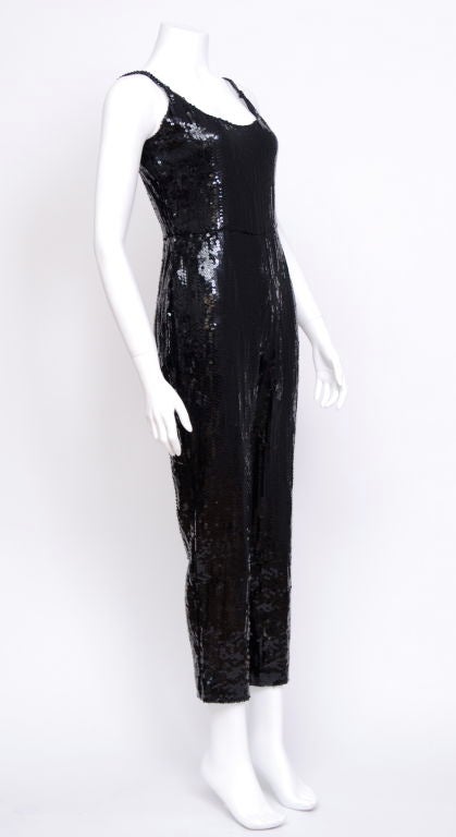 Black sequin beaded spaghetti-strap jumpsuit with 3/4 length pants, zippered side. Fits a size 2-4.