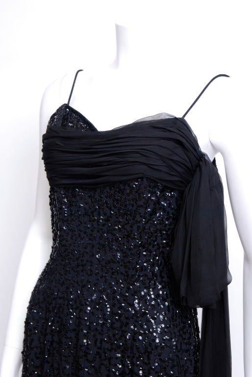 Best and Company black silk crepe gown with a black silk chiffon sash at bust. The sequins swirl throughout the gown with a gradation towards the bottom. (all sequins in tact). Pristine condition.
