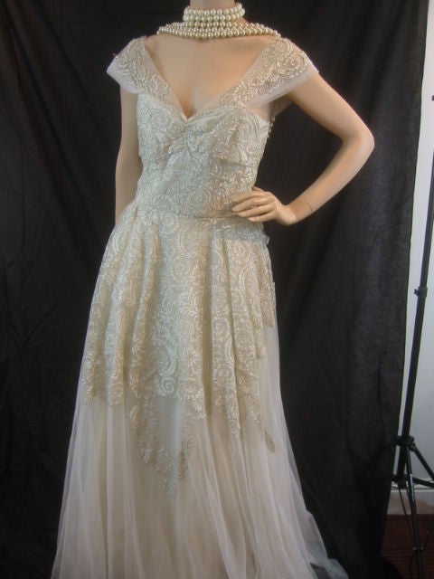 Vintage 1950's Fantasy Lace and Tulle Wedding Gown from Pierre Balmain<br />
<br />
This stunning gown is made of white tulle and lace with gold thread woven through it. Designed with a sweetheart neckline with wide lace and tulle straps. The