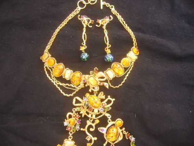 Stunning Crystal Jeweled Bib Necklace and Earrings from CHRISTIAN LACROIX<br />
<br />
This wonderful necklace and earring set is made of plated brass which has been casted into a unique design. The necklace is accented with glass cabachons and