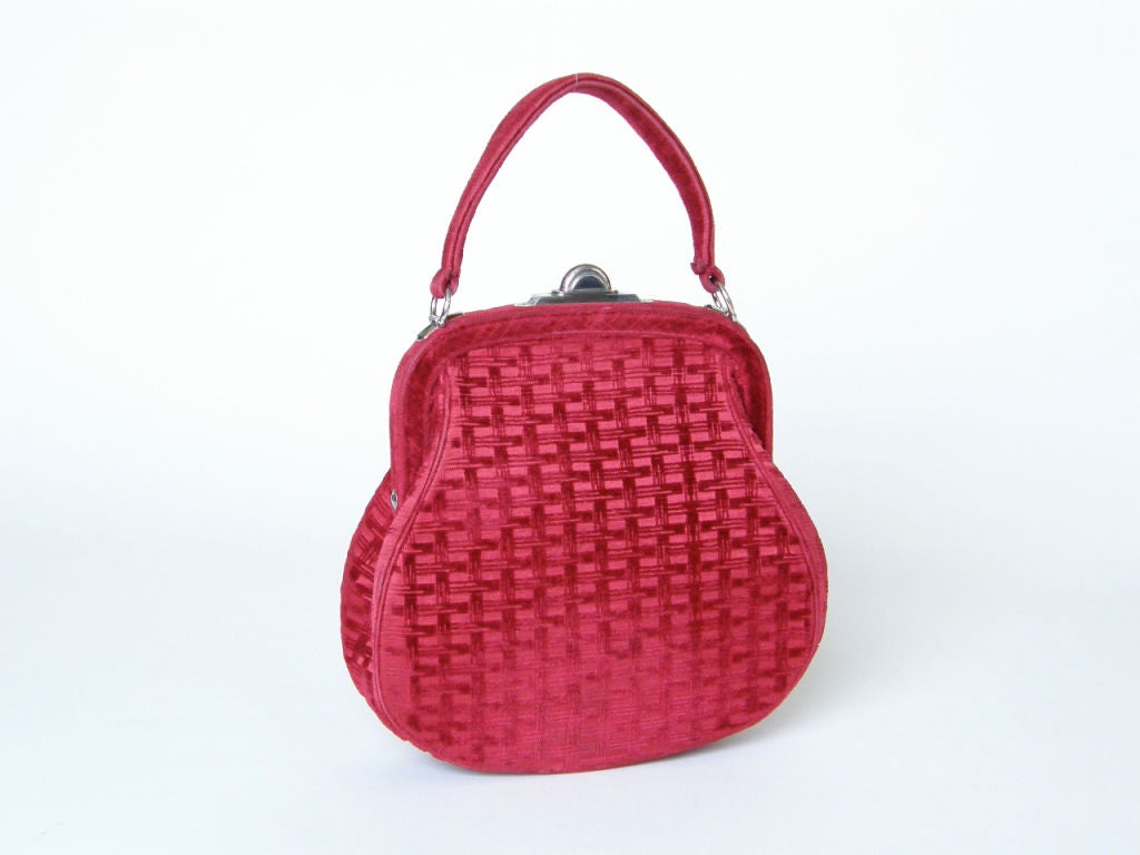 This lovely Roberta Di Camerino bag has a basket weave pattern in the cut velvet. The color is rich and bright and is somewhere between a fuchsia and a burgundy. The false pocket on the front of the bag is accented with 
