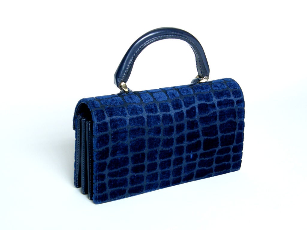 This classic Roberta di Camerino handbag features a textured velvet with a reptile skin pattern. The velvet reads as a midnight blue with electric blue highlights, though the exact colors change depending on the light. The handle, the accordion