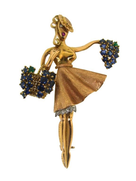 A pair of fantastic pins by Lacloche made in the shape of woman's figures holding colorful baskets, flowers and fruits.