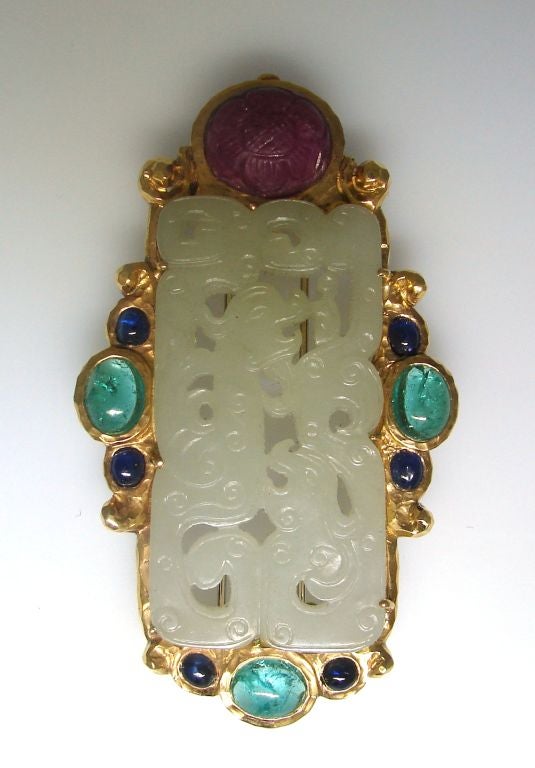 Stunning yellow gold brooch by David Webb<br />
Amazing carving on jade in French Chinois style depicting two Chinese dragons; carved cabochon ruby, cabochon emerald and cabochon sapphire<br />
3