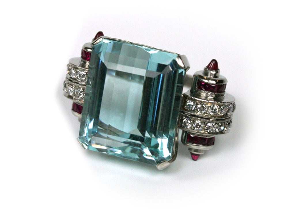 The 32-ct emerald-cut aquamarine is set in platinum with rolled side ornaments of diamonds (approx 1.65 ct total) and natural rubies (approx 1 ct total).