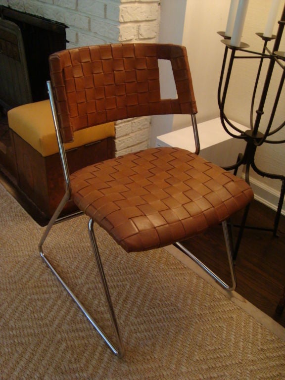 A set of very four very unusual modern dining chairs or games table chairs with inter-woven leather backs and seats, the back splat having rectangular openings at the curves, on chrome sleigh shaped bases. <br />
<br />
A unique and interesting