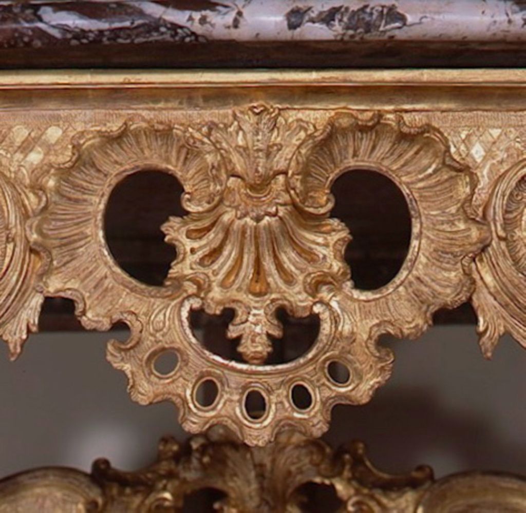 An exceptional German Régence, carved, giltwood console probably inspired after designs by François Cuvilliés in Munich, Germany.  The console is pierced and finely carved with flowers, leaves, cartouches, and figures on each side.  A “rouge royal”