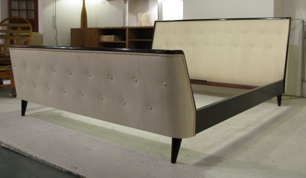 Free-standing Queen size bed with curved and upholstered headboard and footboard<br />
and walnut frame and runners.  An elegant piece of mid-century Italian design.<br />
Refinished and newly upholstered in tufted cream raw silk.