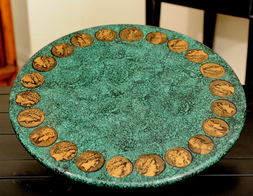 A highly decorative pair of Fornasetti occasional table <br />
tops with a neoclassical motif.