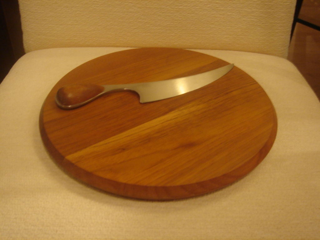 A round teak cheese cutting board and matching knife by Dansk in the Torun pattern.  Made in Denmark, circa 1950.  Knife handle fits into an indentation in the board.