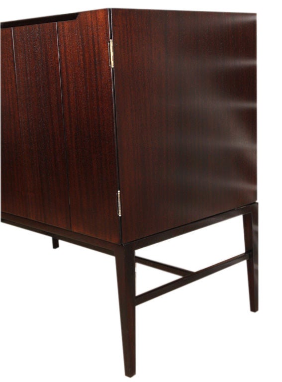 Paul McCobb attributed 8 door sideboard custom made and designed for a Manhattan residence Ca. 1960. Finely crafted and recently restored in a deep brown open grain mahoghany finish. The piece has 2 sets of tri-folding doors on either end that house