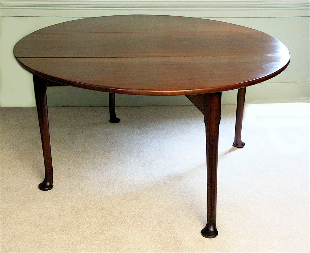 An oval walnut gate-leg drop-leaf small dining table, Queen Anne<br />
footed; in old mellow finish.  Seating four or six.