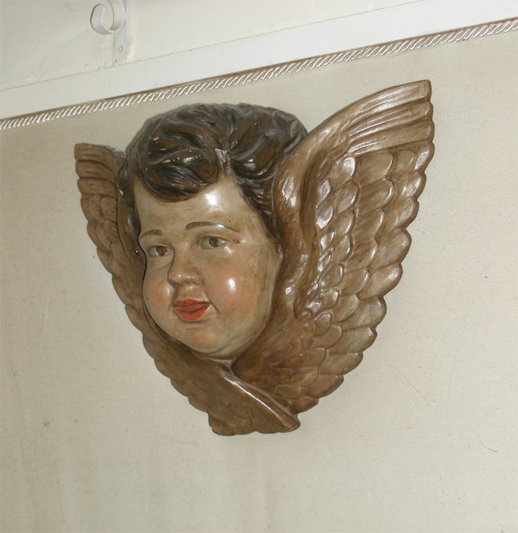 1770s polychrome wooden sculpture of an angel's head, painted and with stucco elements.
