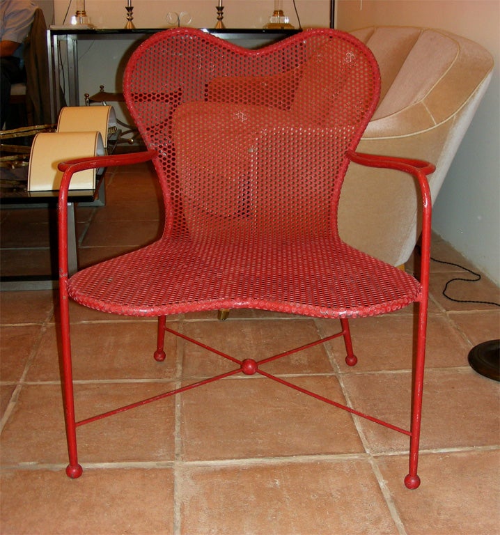 Two 1950s armchairs in red perforated metal by Jean Royere.