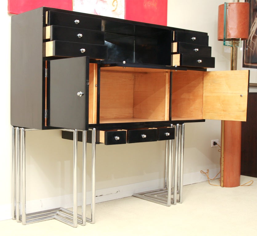 Black lacquer cabinet with compartments on tubular chrome base.