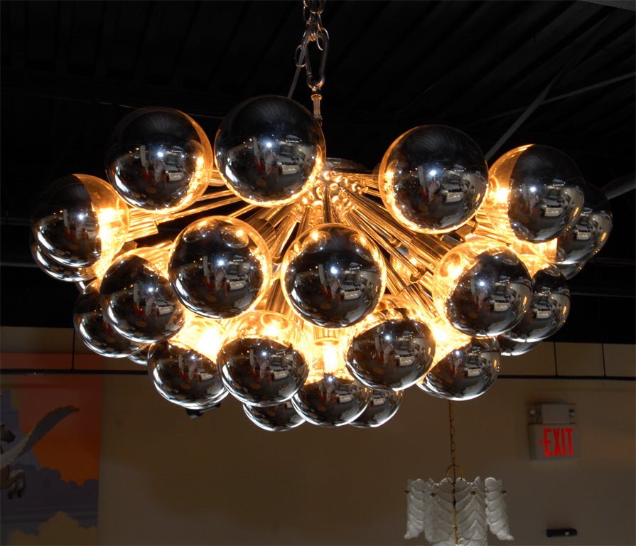 A rare and fantastic pair of 1960's large flush mount starburst chandeliers with 36 lights. Each light is coverd with large chrome capped glass shades. The chandeliers were originally hung in the <br />
