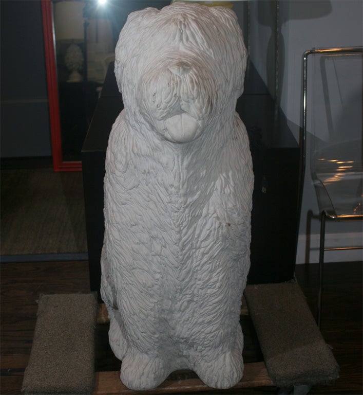 A fantastic, slightly larger than life-size concrete sheepdog with detailed shaggy hair.