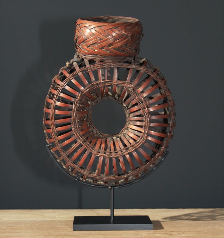 Chinese bamboo sparrow basket. The torus form basket for carrying sparrows home from the market. <br />
On contemporary metal stand. <br />
Early - Mid 20th century<br />
11
