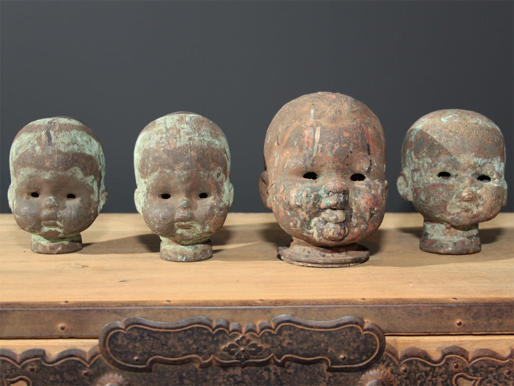 A group of four copper casting molds for doll heads.<br />
4
