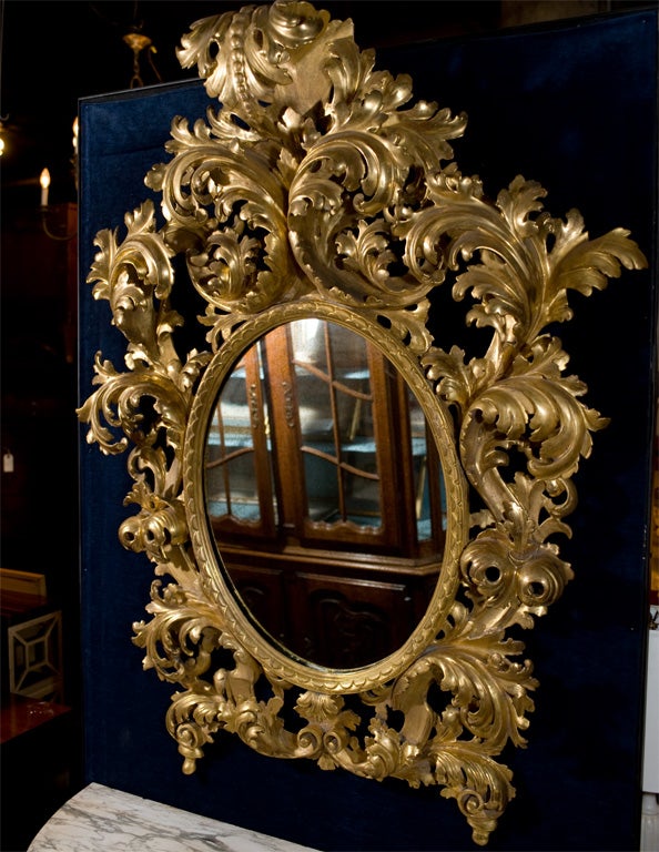 Elaborately hand carved Venetian water gilt oval mirror.Large proportions.