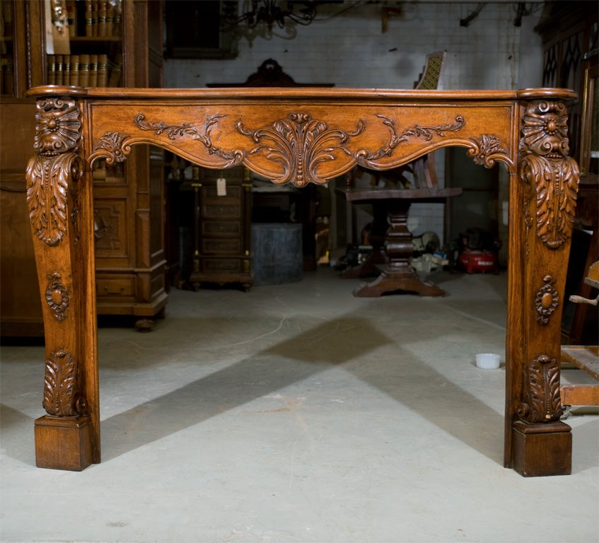A quality carved oak and walnut Louis XV style fireplace surround.