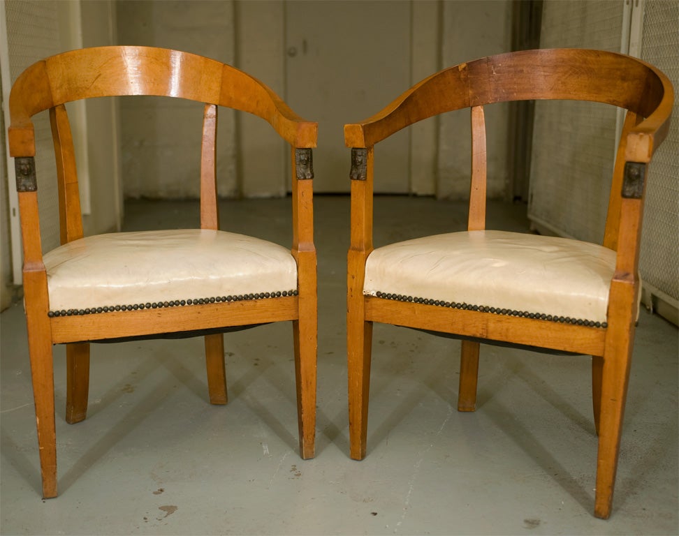 Curved back fruitwood arm chairs with carved mounts at front of arm, upholstered seat.