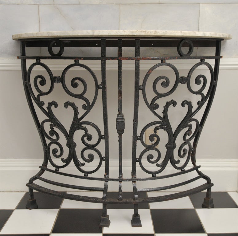 This exceptional cast iron table with concentric heart design to the front was converted from a mid-19th century balcony railing sourced from an important building in London. Topped with a half-round of 3/4 inch thick antique Carrara marble, this