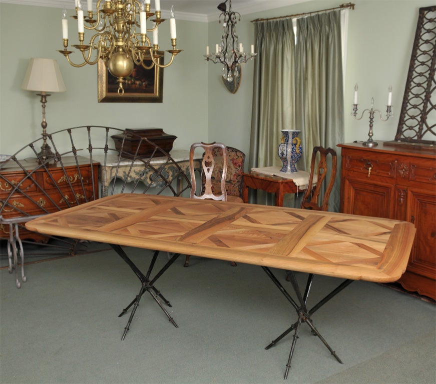 Unique 19th century bleached walnut parquet flooring from a French chateau graces this tabletop with a Giacometti-inspired iron base that is hand planed and welded. Table includes two  finished  parquet 21.5 inch extensions that are placed on its