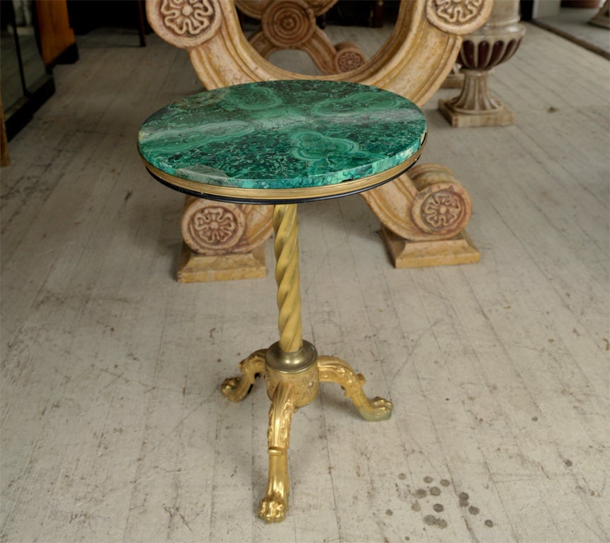 A GILT BRONZE GUERIDON WITH ORIGINAL  MALACHITE TOP. PAW FEET, TWISTED CENTRAL COLUMN