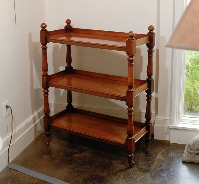 This 19th century English three-tiered rectangular mahogany trolley is raised on brass casters for ease of movement. With a nice warm finish, it is raised on finely turned supports, alternating blocks and balusters and topped with round finials. A