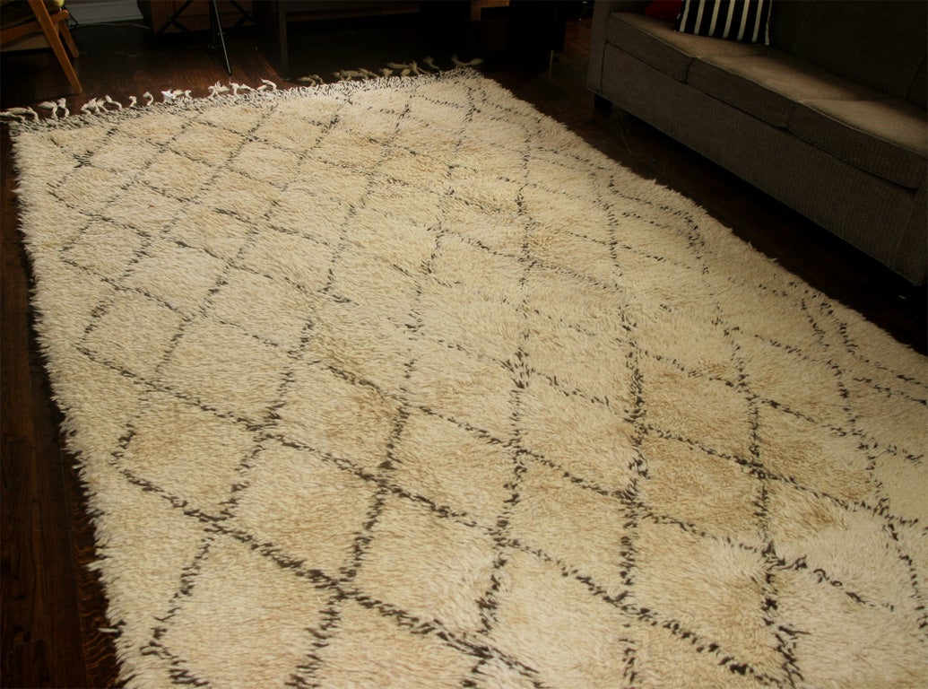Hand-loomed, Deep pile rug with a natural ivory wool field and classic diamond motif in dark brown, fringed at one end. Others available.