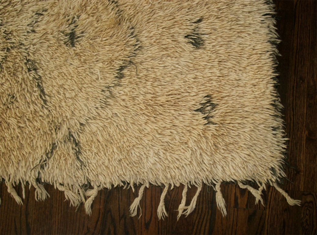 Shaggy Moroccan rug. A deep pile, natural ivory wool with a deep brown diamond motif. Fringed on one end. Others available.