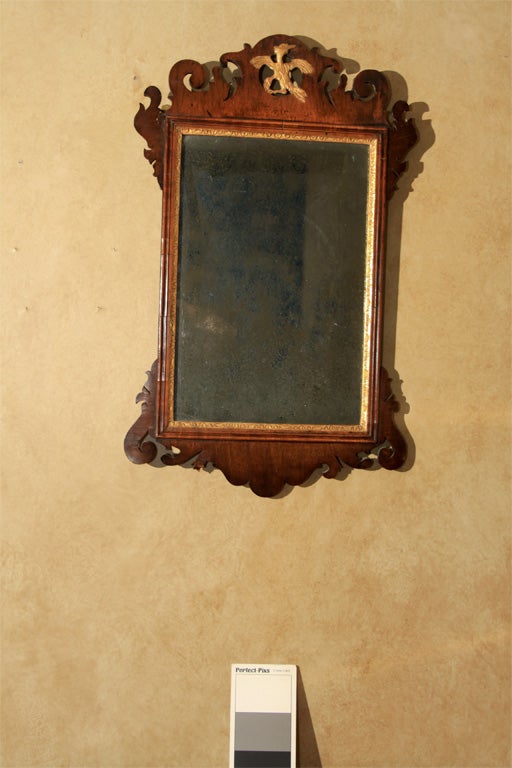 This mahogany mirror has a typical scrolling top with a gilt eagle in the center. Mirrors were important decorative items in eighteenth century interiors and reflected the furniture design.

OFFERED AT THIS 50% OFF PRICE FOR  2015 ONLY!